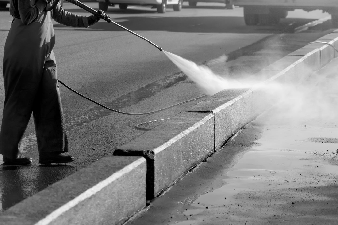 Pressure washing curb outside commercial building